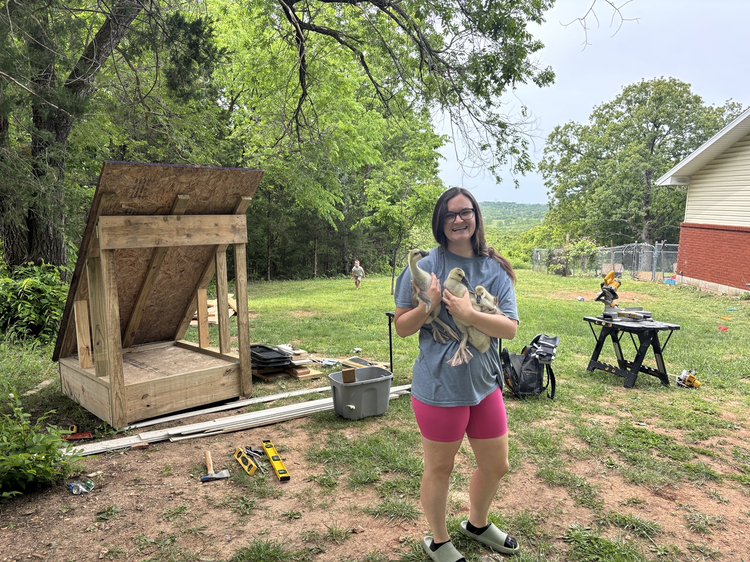 Claire smiling outdoors while holding three young birds