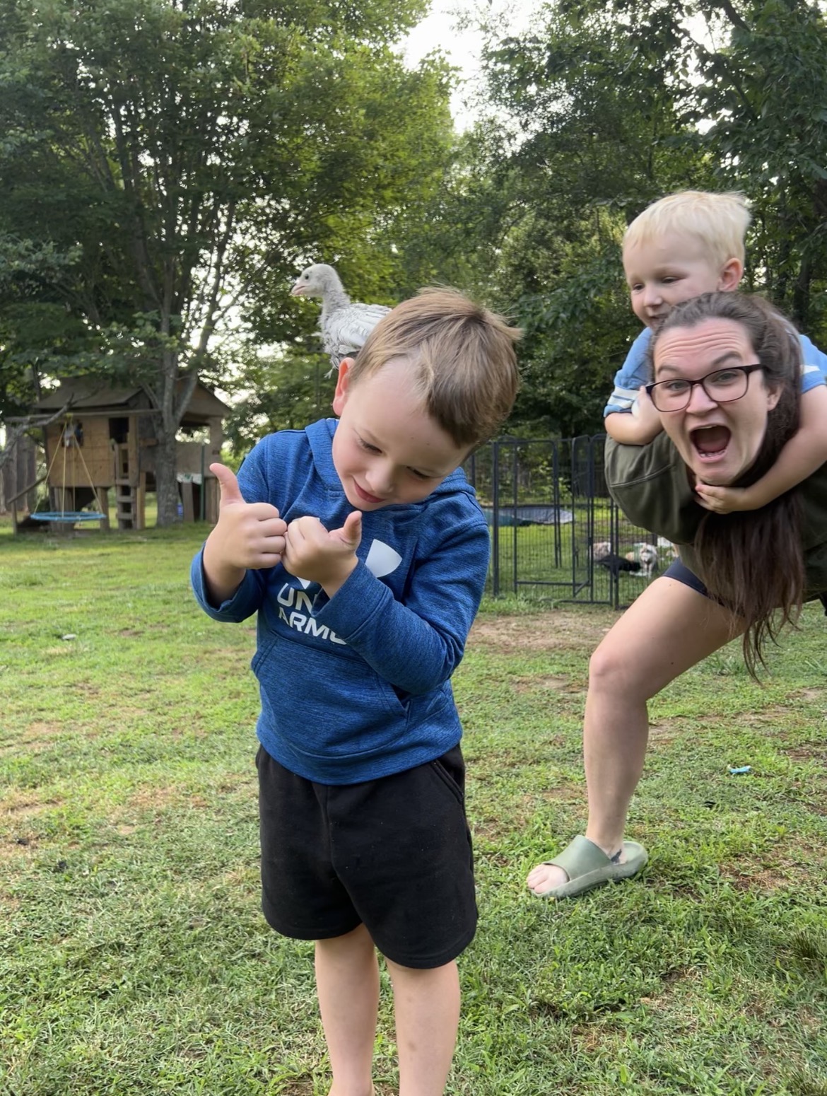Claire and her children outdoors with a young bird perched nearby